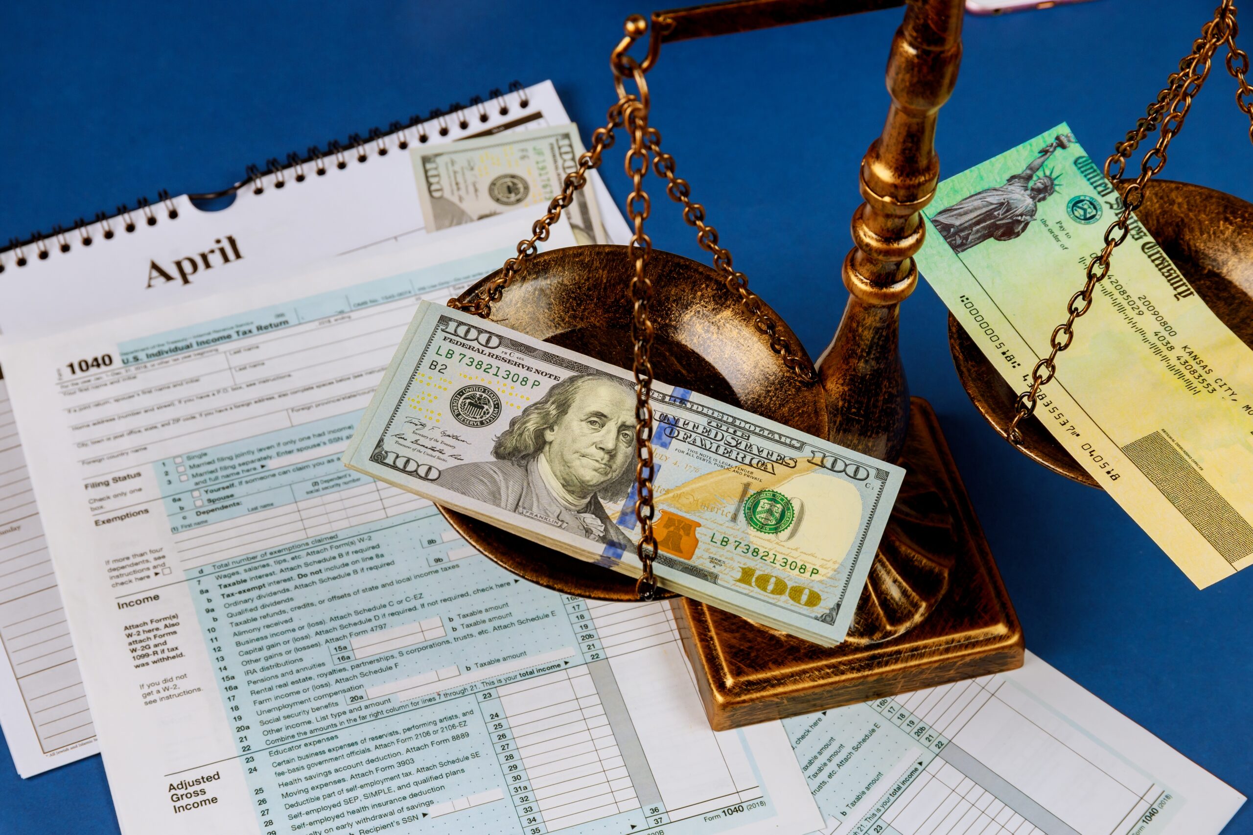 Individual Income Tax Return Law concept scales of justice criminal liability for non-payment of taxes of one hundred dollars bill form 1040 on U.S.